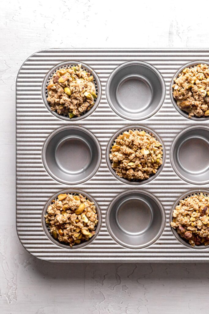 muffin batter with oat streusel on top in muffin pan