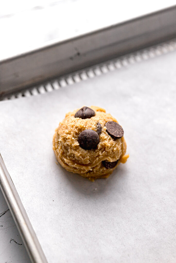 cookie dough ball on parchment lined baking sheet