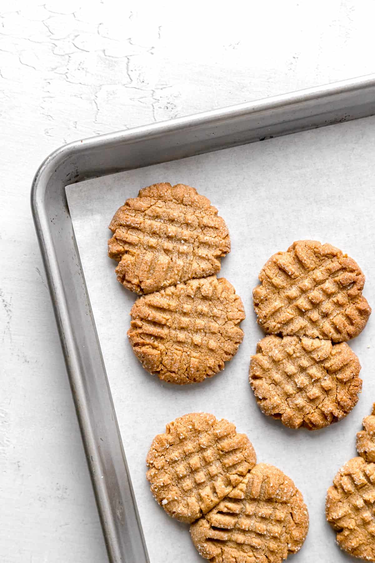 baked flourless peanut butter cookies on parchment lined baking sheet.