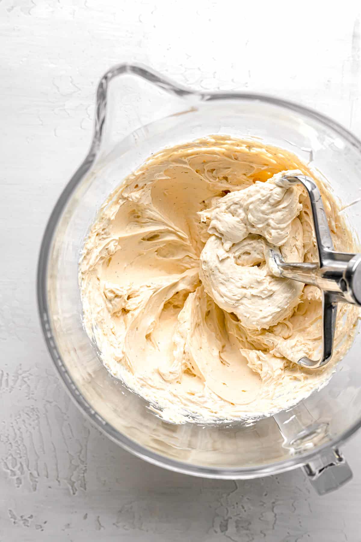 salted caramel swiss meringue buttercream in glass mixing bowl.