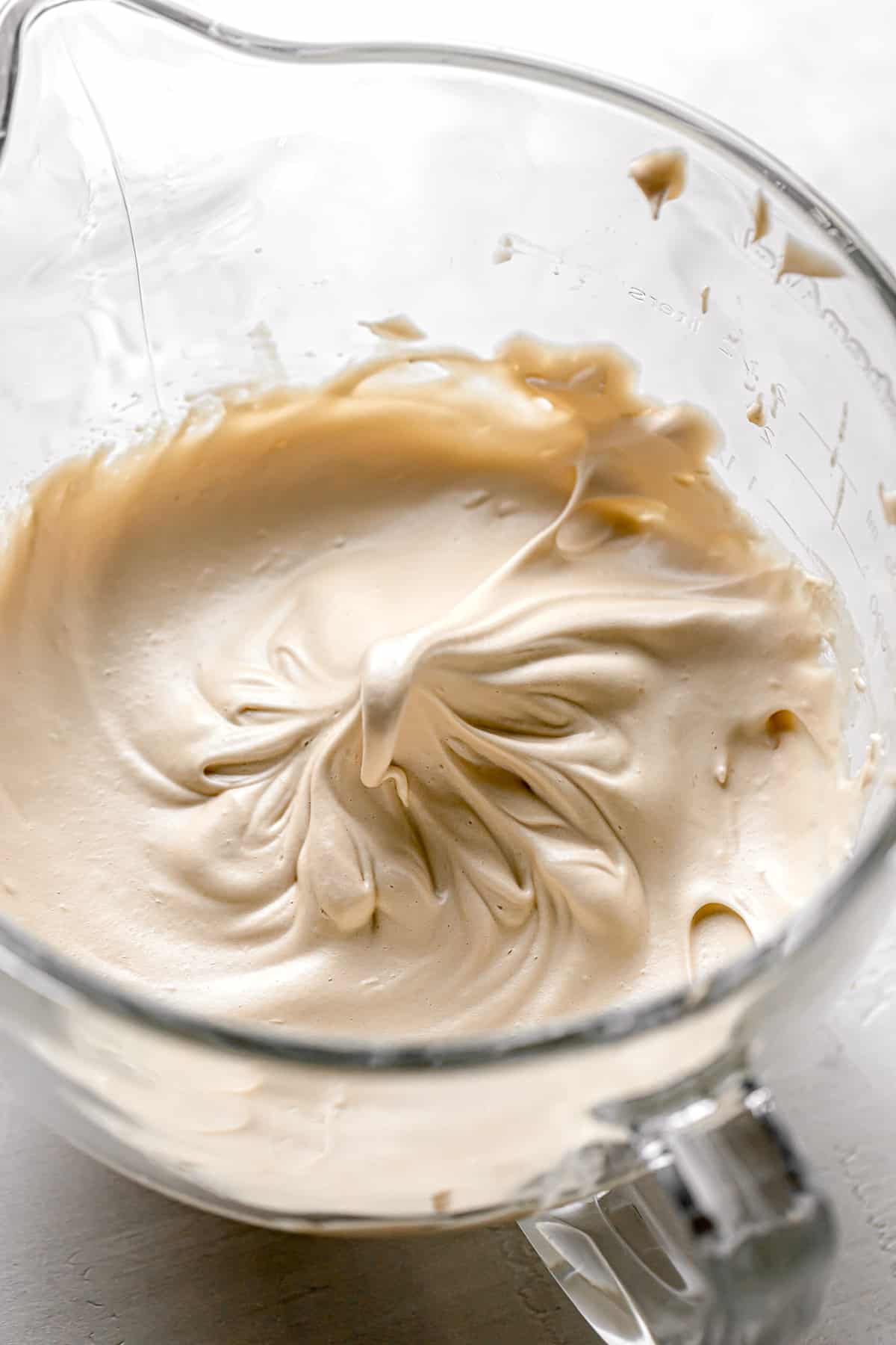 brown sugar swiss meringue in glass mixing bowl.