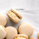 salted caramel macarons pilled on parchment paper