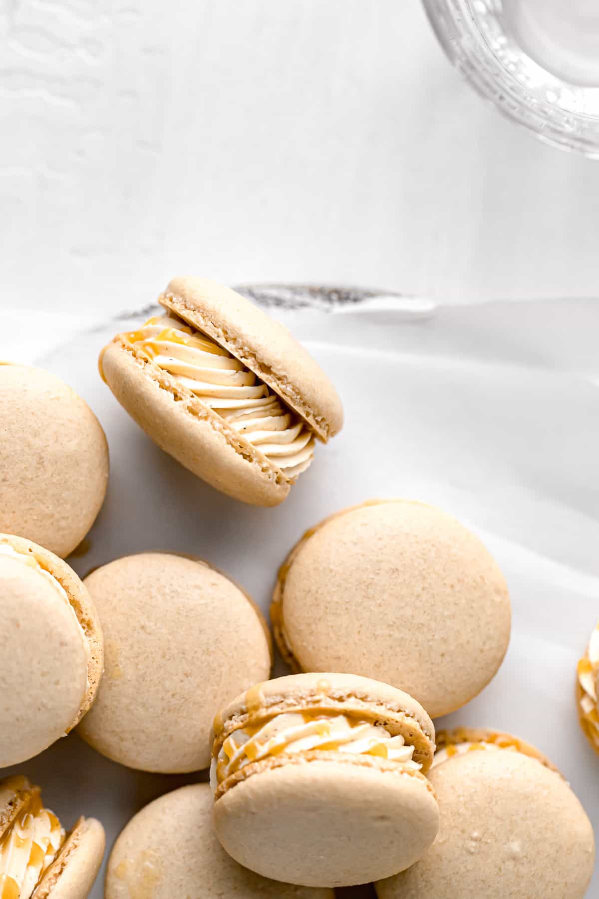 salted caramel macarons pilled on parchment paper.