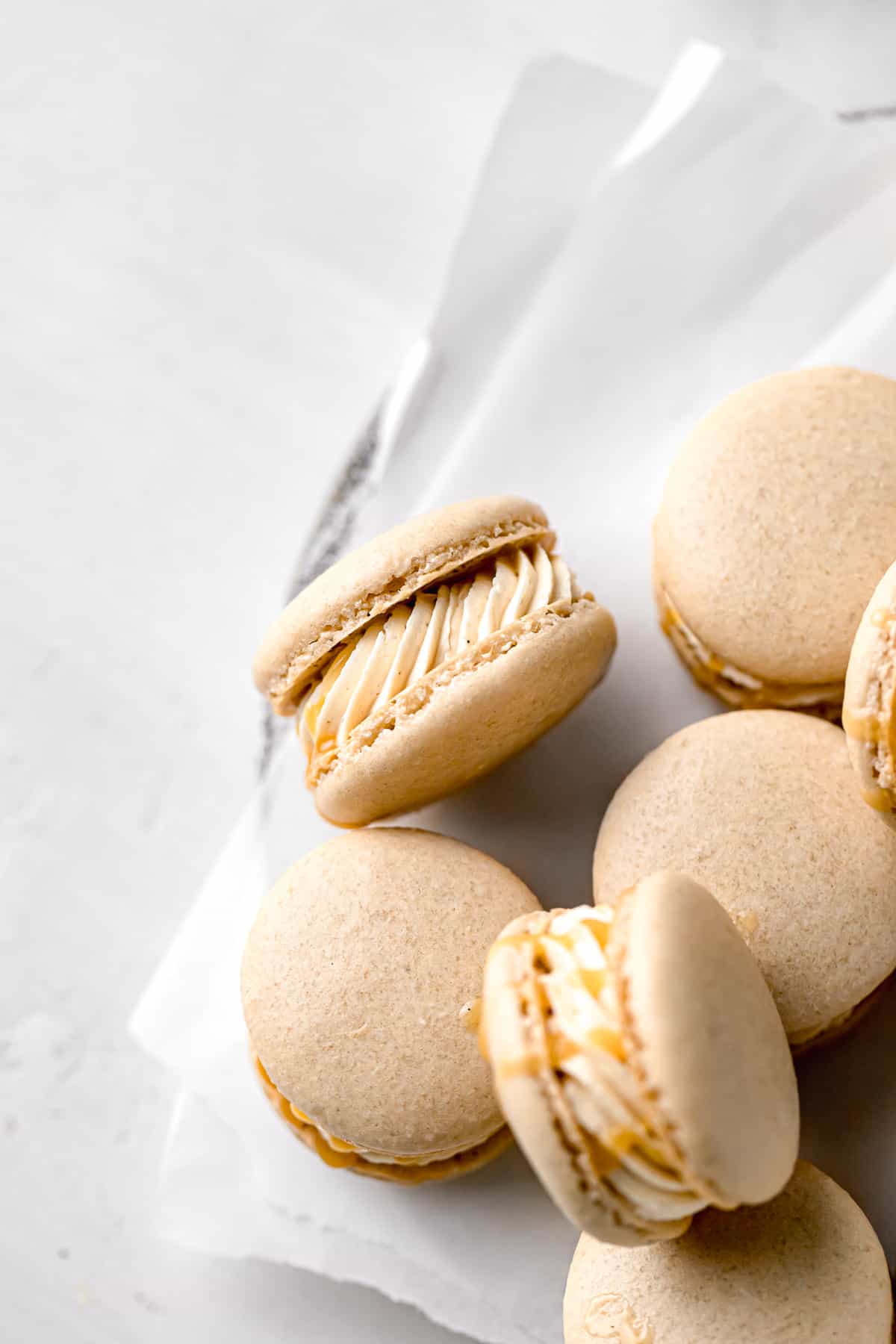 salted caramel macarons piled on parchment paper