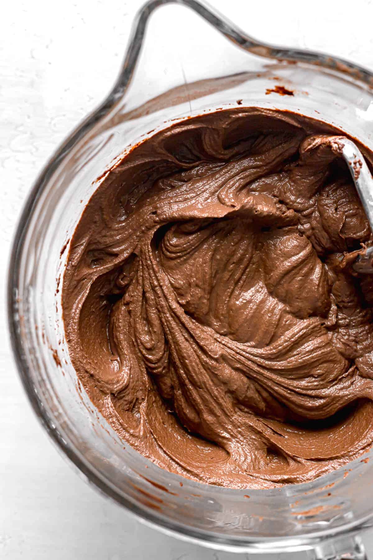 chocolate frosting in glass mixing bowl.