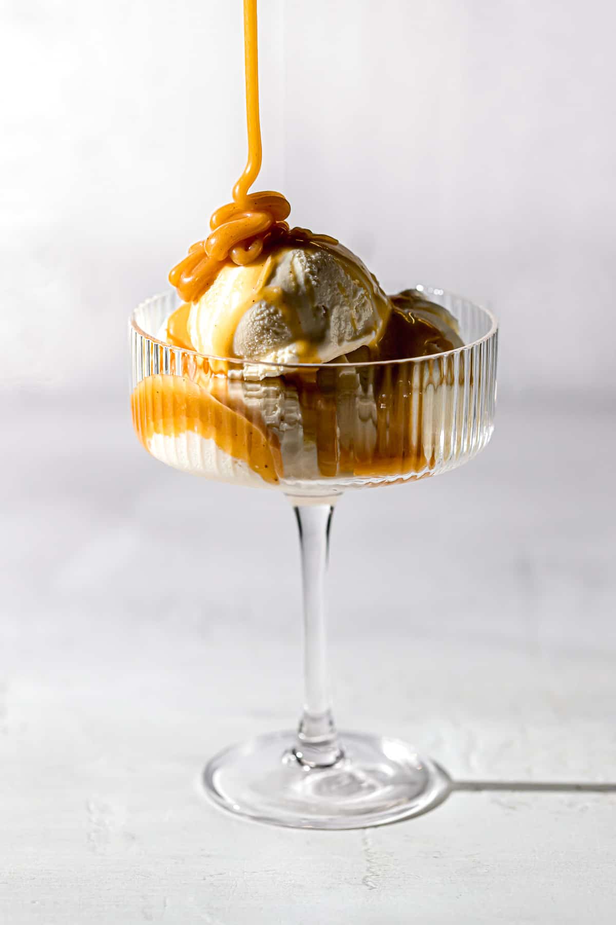 foolproof salted caramel sauce drizzled over vanilla ice cream in coupe glass.