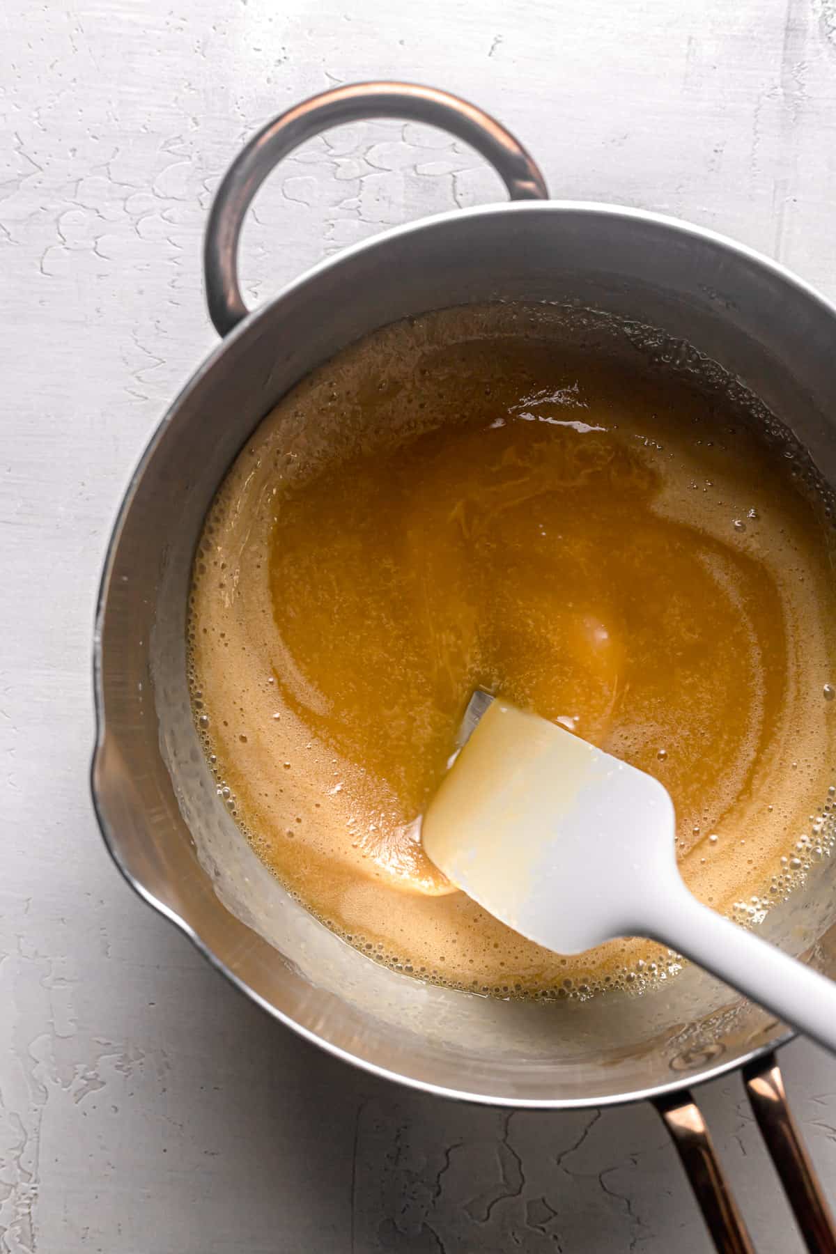 heavy cream being stirred into caramel.
