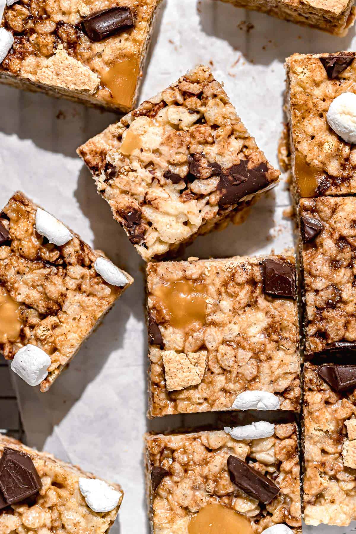 caramel rice krispie treats scattered on parchment paper.