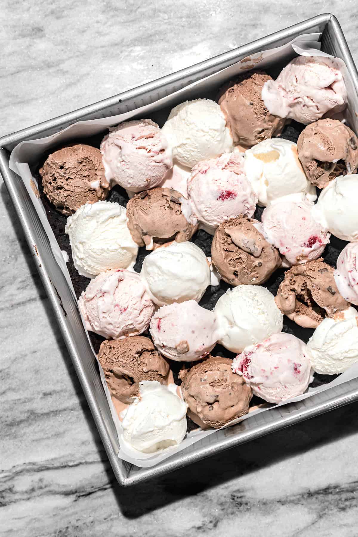 scoops of ice cream on top of first brownie layer.