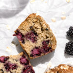 blackberry oatmeal muffin cut in half on parchment paper