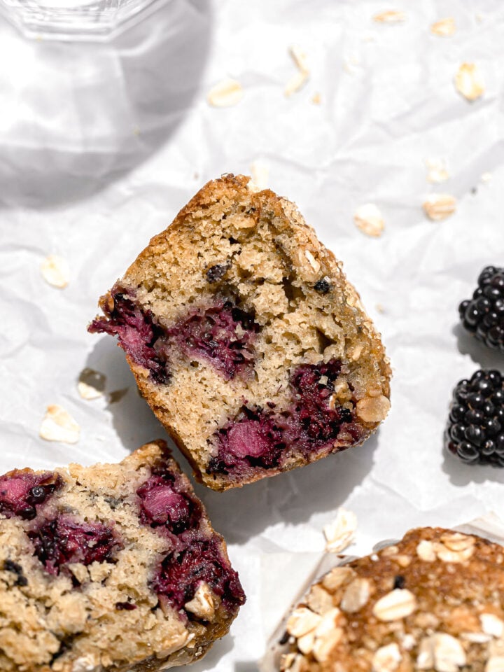 blackberry oatmeal muffin cut in half on parchment paper