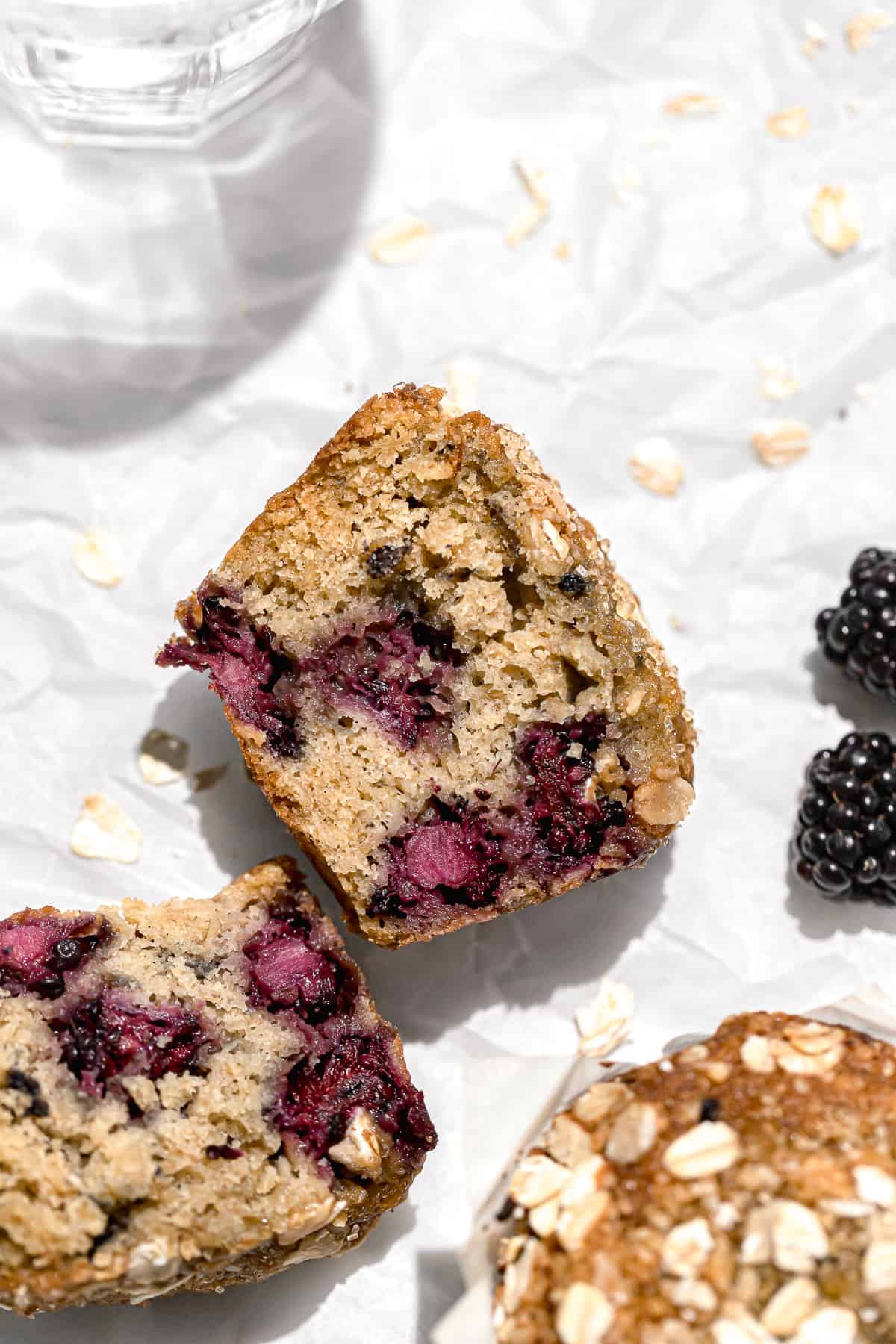 blackberry oatmeal muffin cut in half on parchment paper.