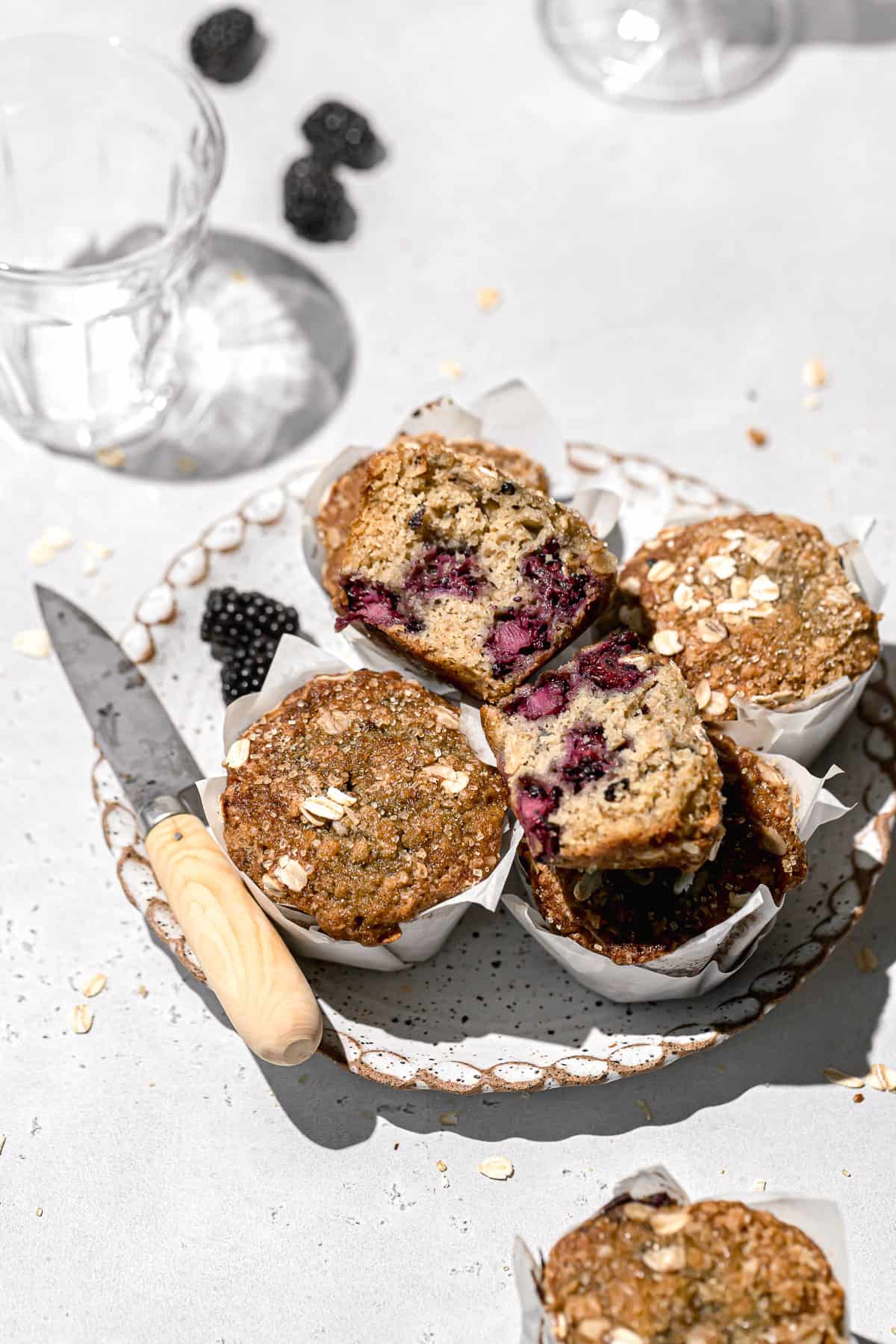 blackberry oatmeal muffins piled on plate.