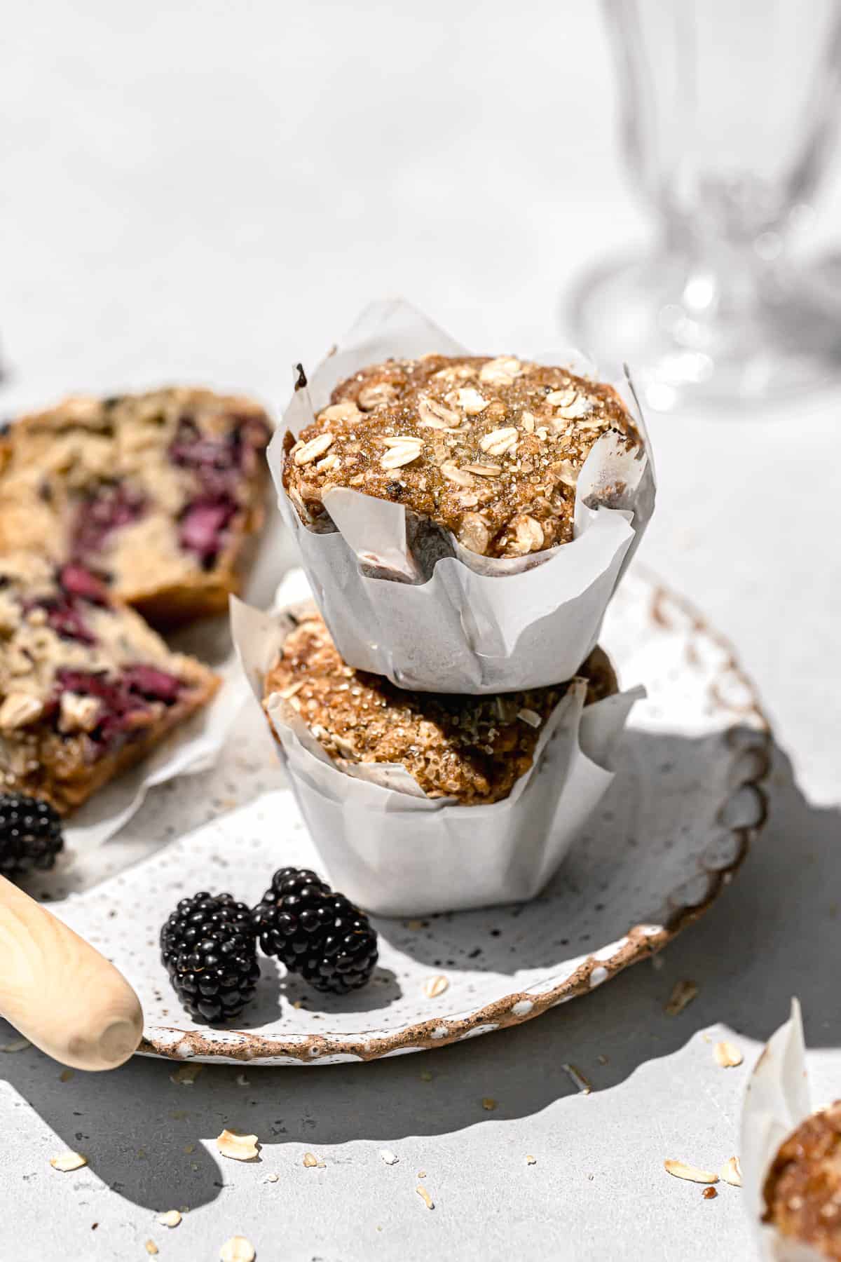 blackberry oatmeal muffins stacked on plate.