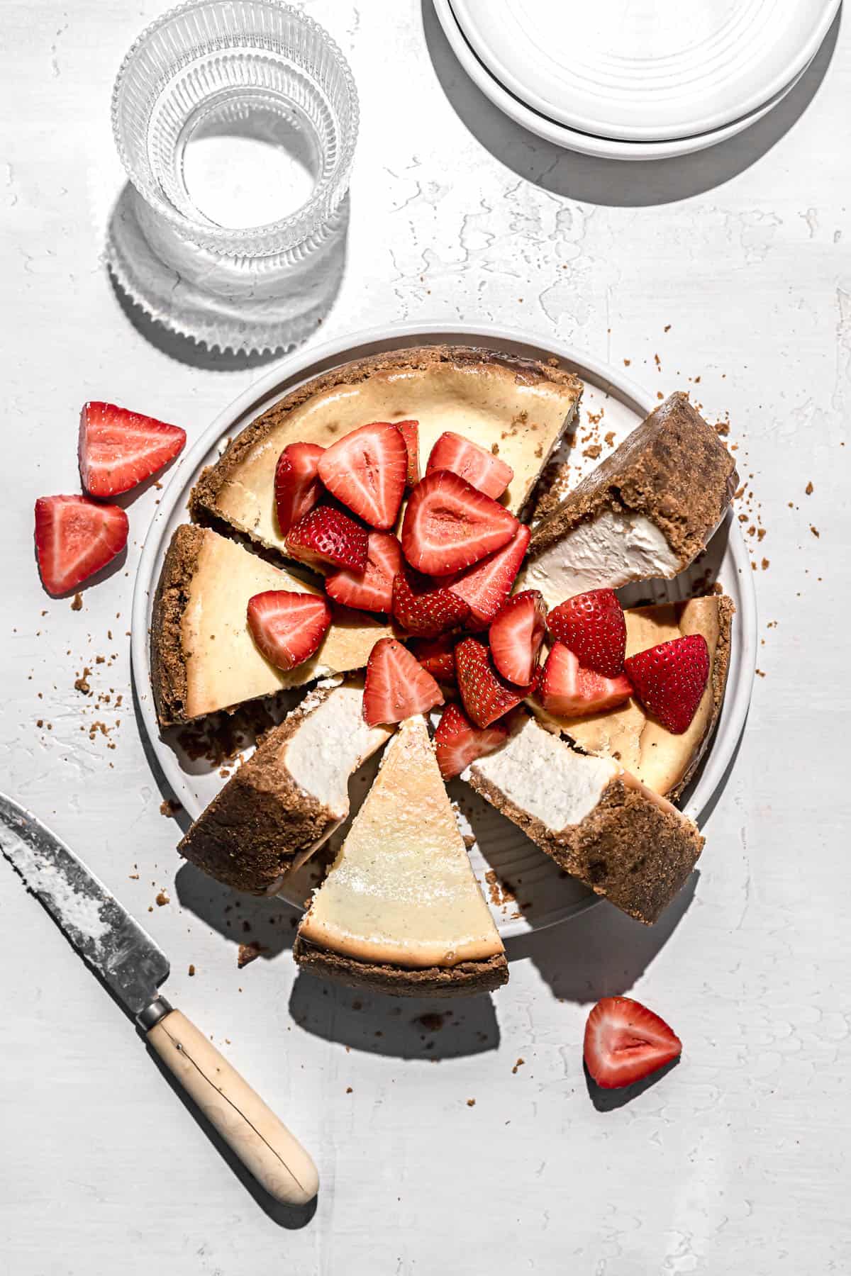 ricotta cheesecake with strawberries cut into slices on white plate