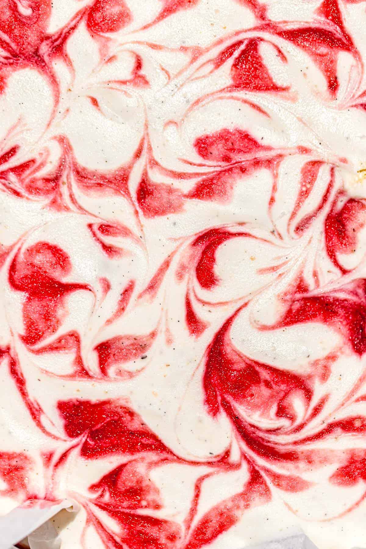 close up of strawberry syrup swirls in no churn ice cream.