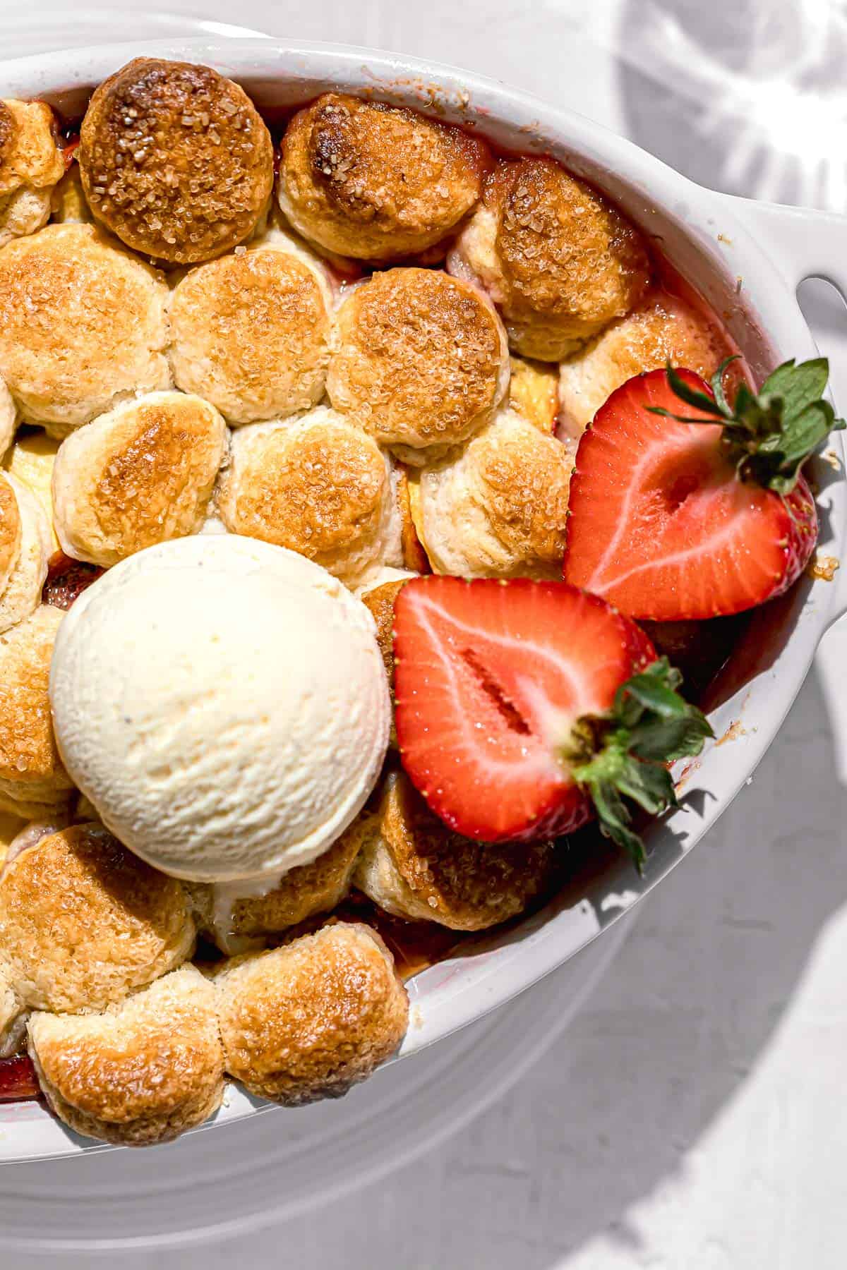 strawberry peach cobbler with scoop of vanilla ice cream.