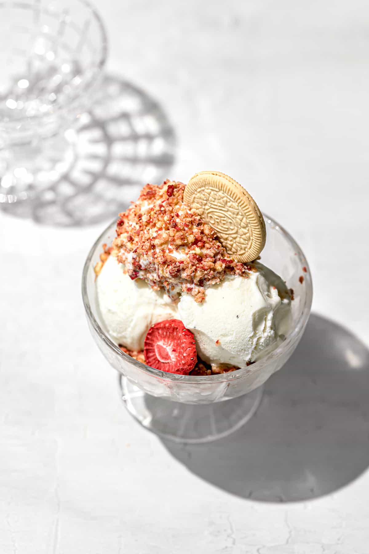 ice cream rolled in strawberry shortcake crunch in glass bowl.