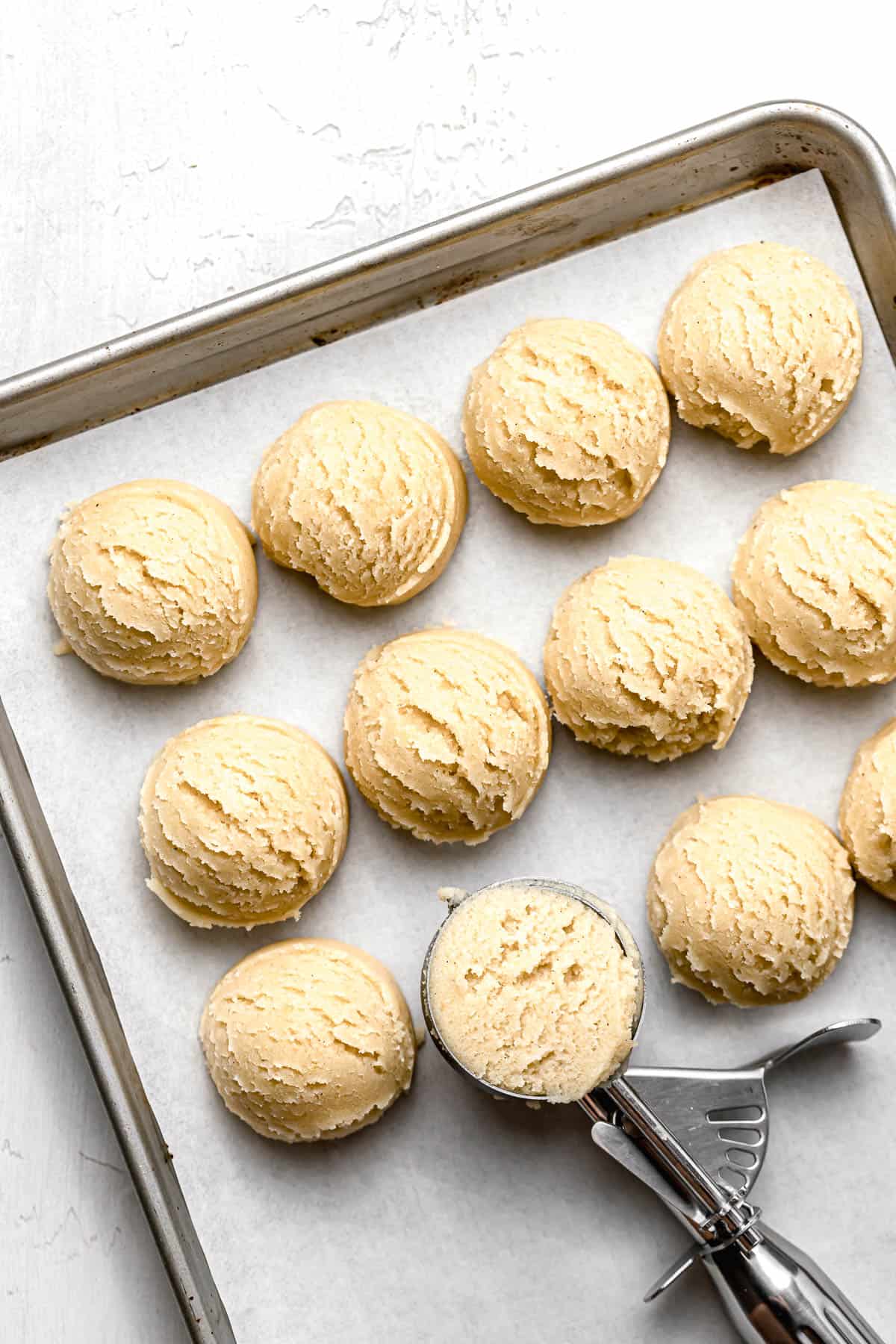 brown butter snickerdoodle cookie dough balls on baking sheet.