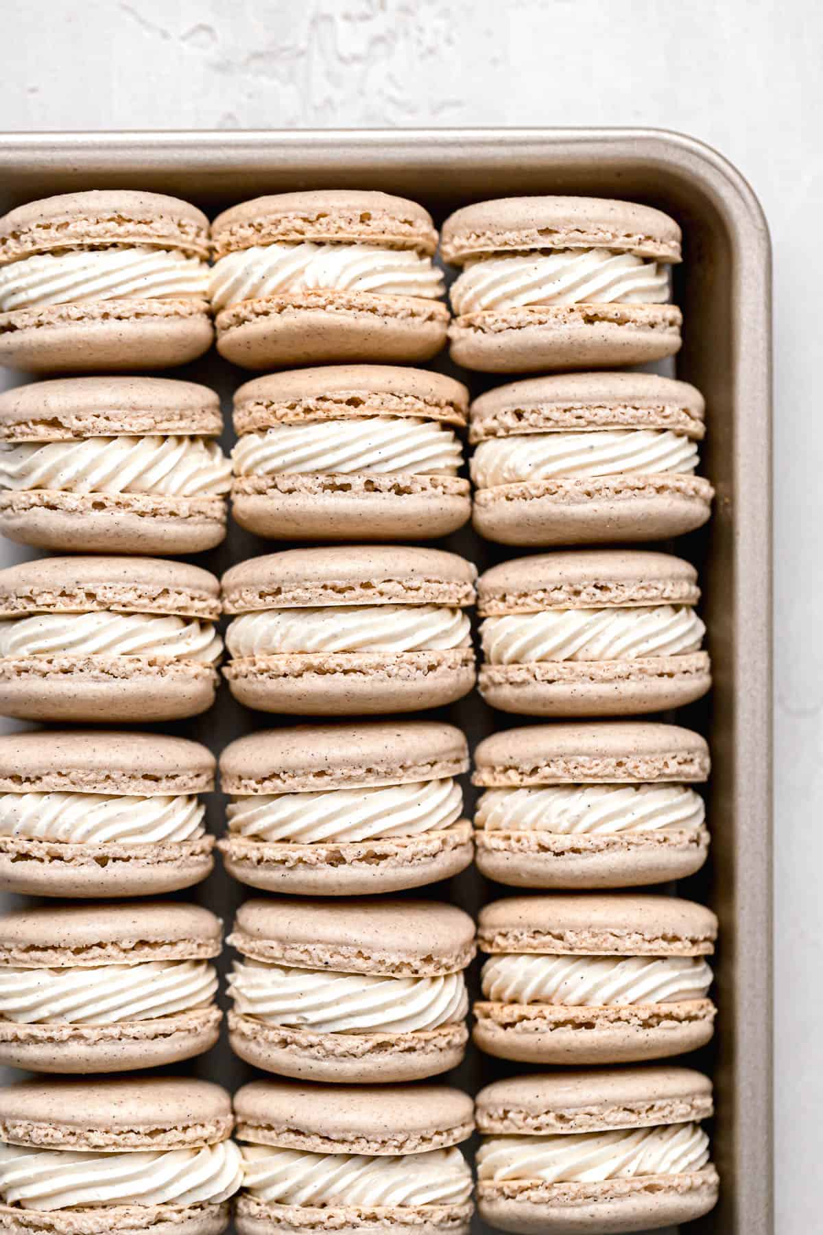 chai macarons lined up in baking sheet