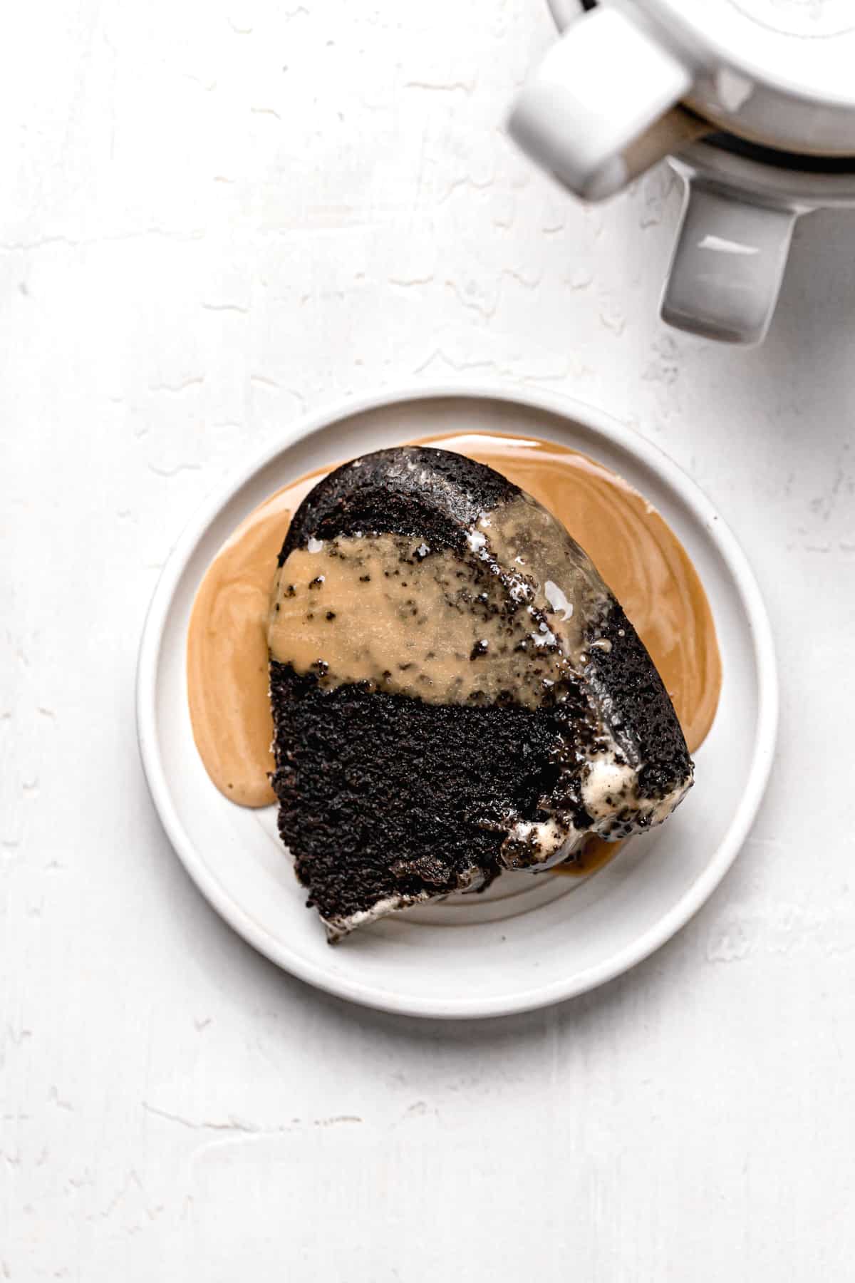 one slice of chocolate espresso cake on white plate with espresso glaze.