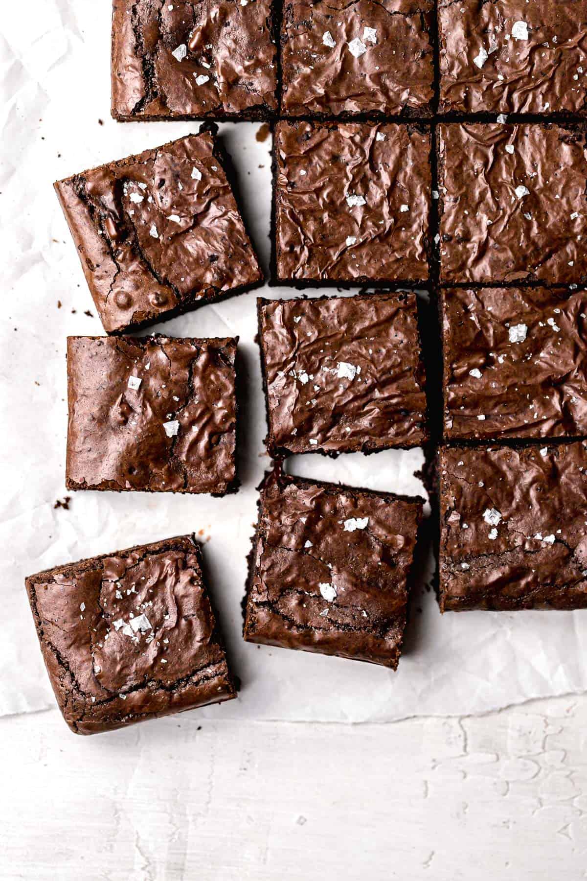 dairy free brownies cut into squares on parchment paper.
