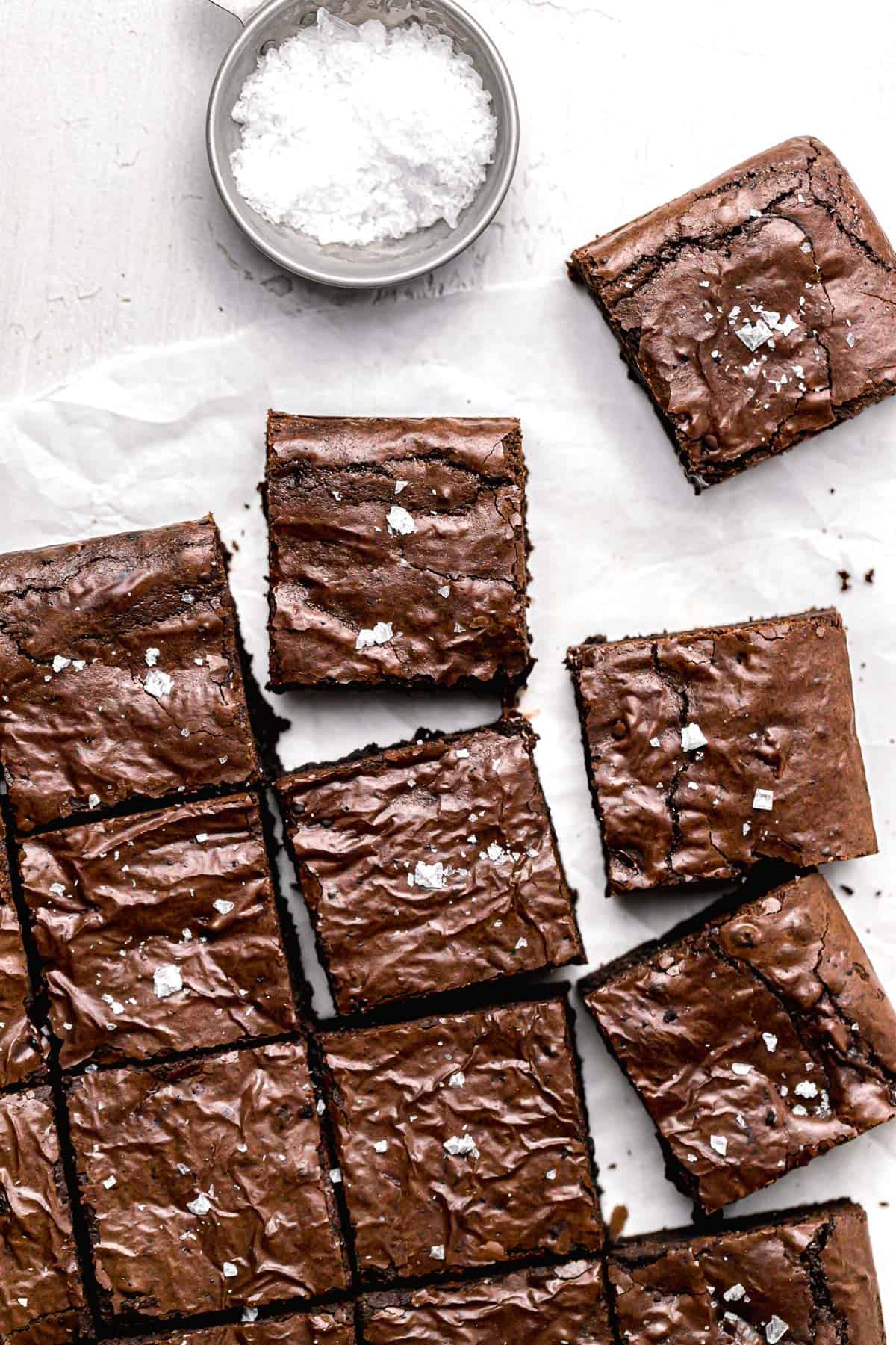dairy free brownies cut into squares and topped with flaky sea salt.