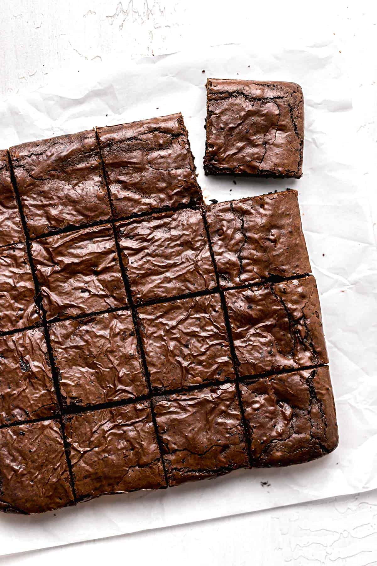olive oil brownies cut into squares on parchment paper.