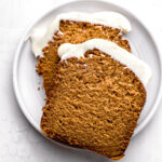 pumpkin bread with cream cheese frosting slices on white plate