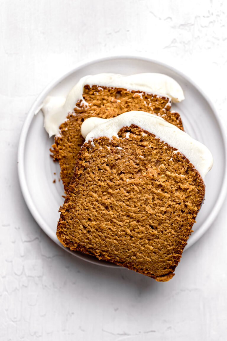 pumpkin bread with cream cheese frosting slices on white plate