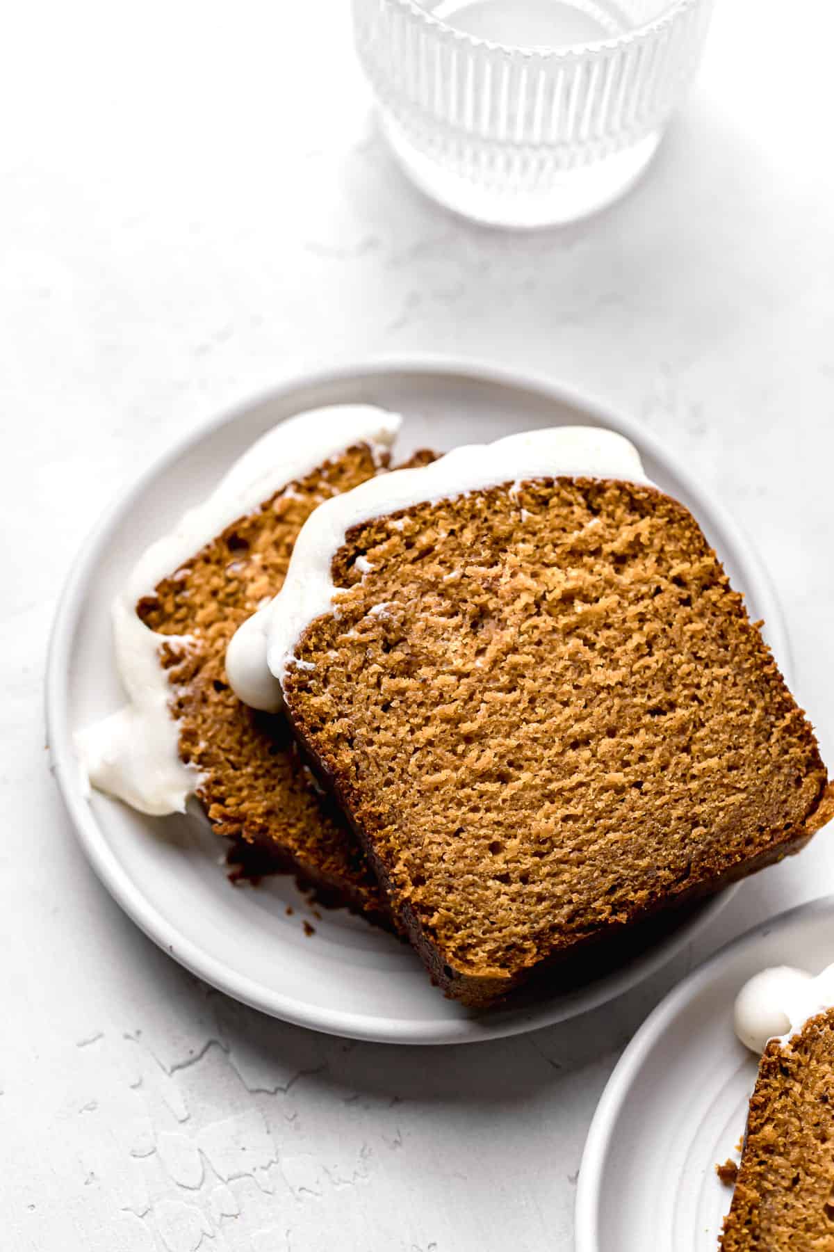two pieces of moist pumpkin bread on white plate.