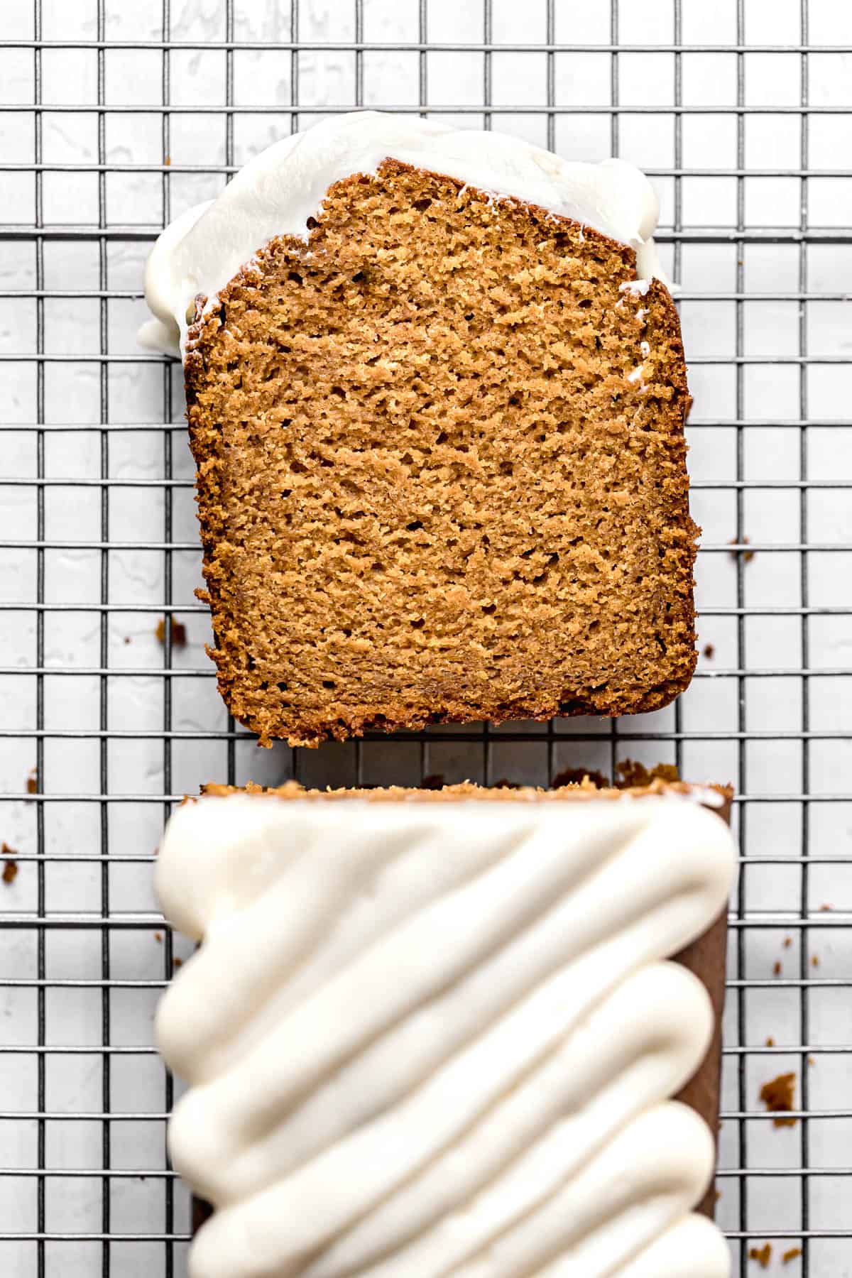 slice of pumpkin bread with cream cheese frosting on wire rack