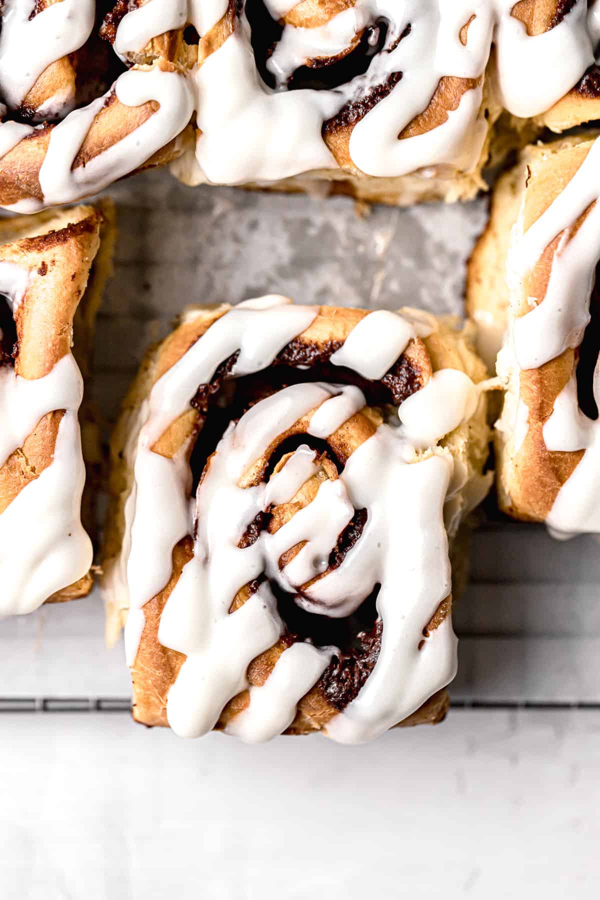 apple cinnamon rolls on parchment lined wire rack