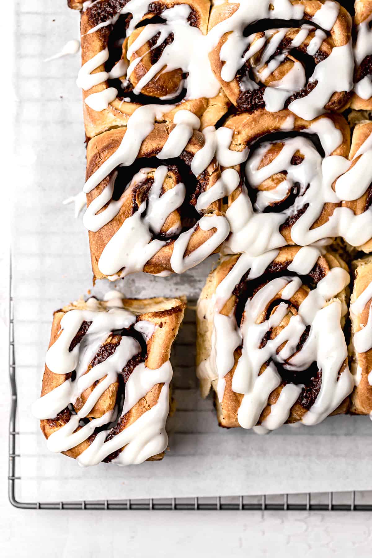 cinnamon rolls with apple pie filling on parchment lined wire rack