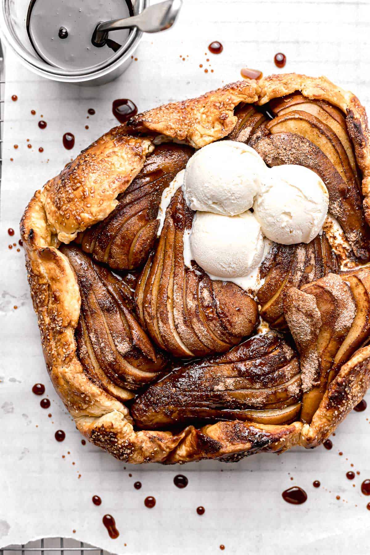 pear galette on parchment lined wire rack topped with ice cream