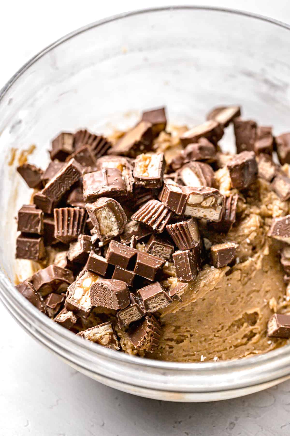 blondie batter and candy bars in glass mixing bowl