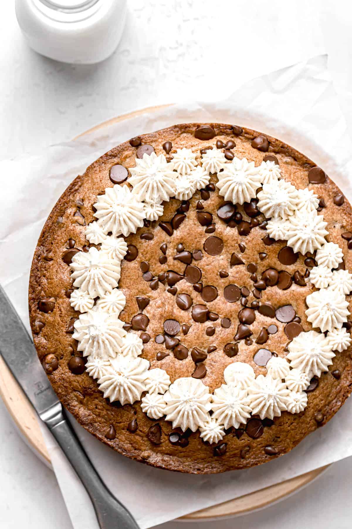 whole chocolate chip cookie cake decorated with buttercream.