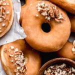 maple donuts with pecans piled on black tray