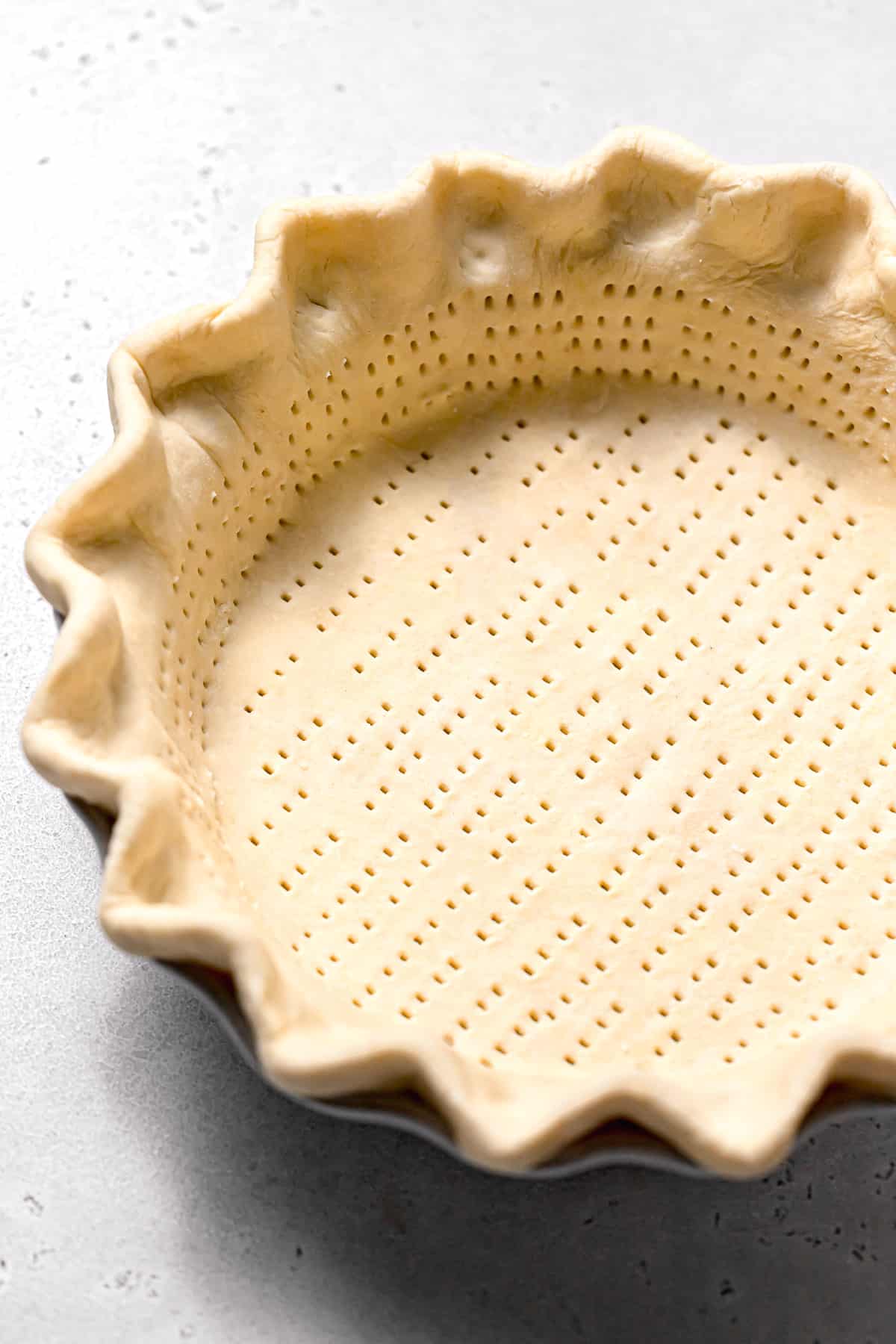 crimped and docked pie dough in pie dish.