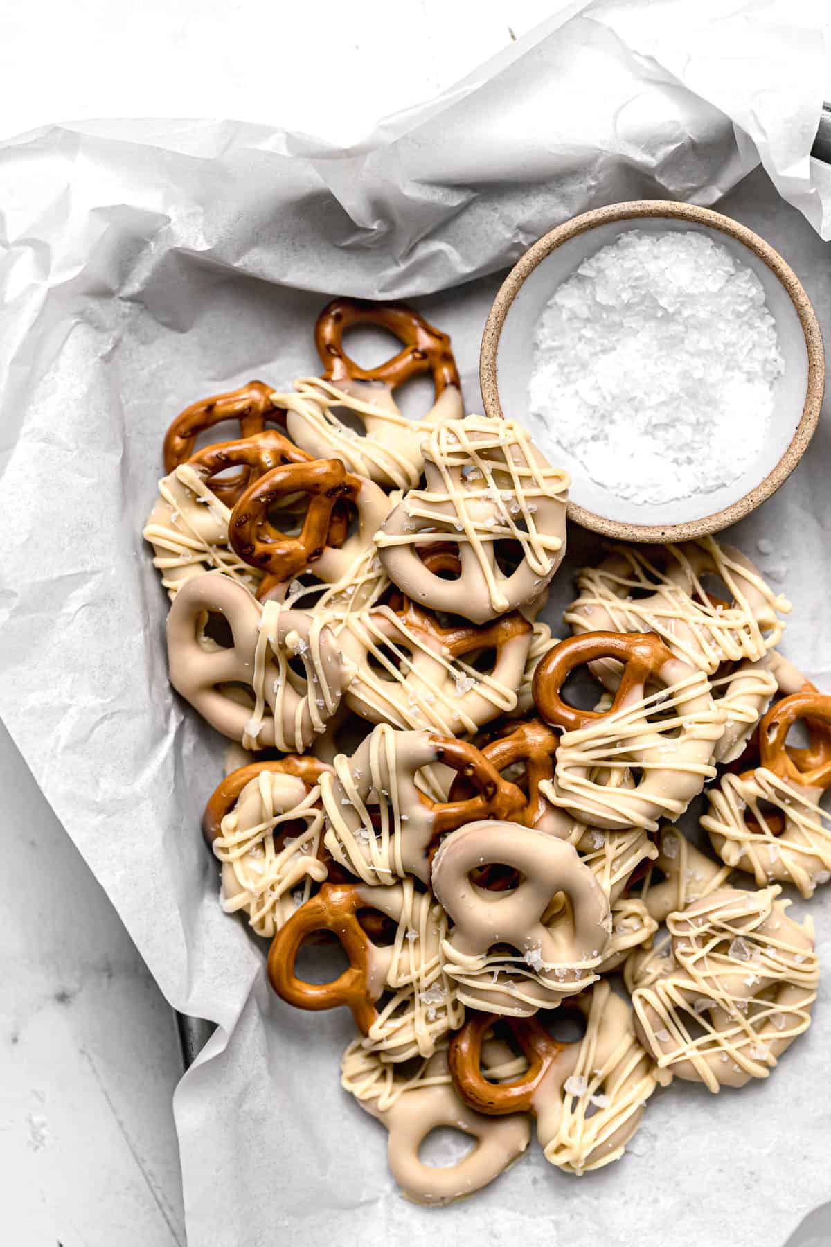 white chocolate covered pretzels in parchment lined baking sheet.