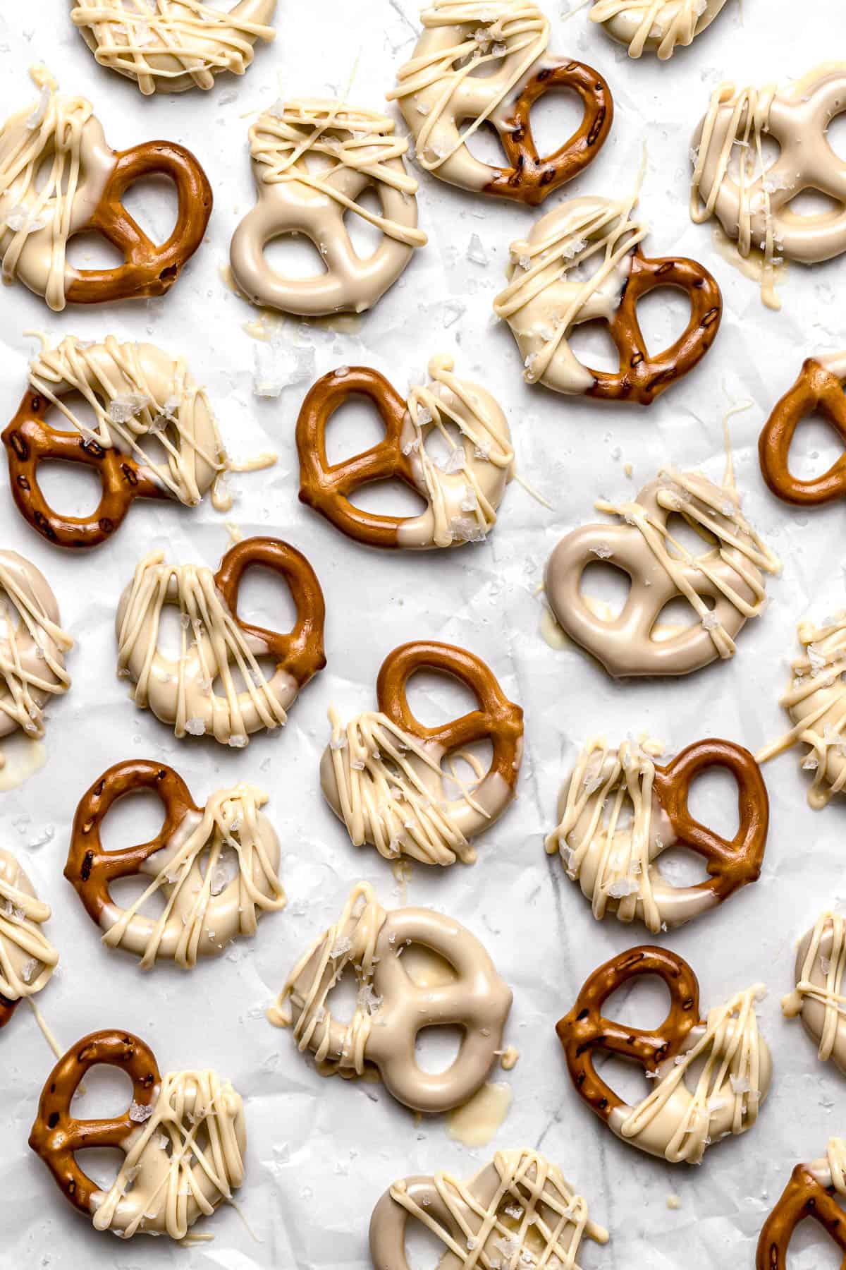 white chocolate covered pretzels on parchment paper.