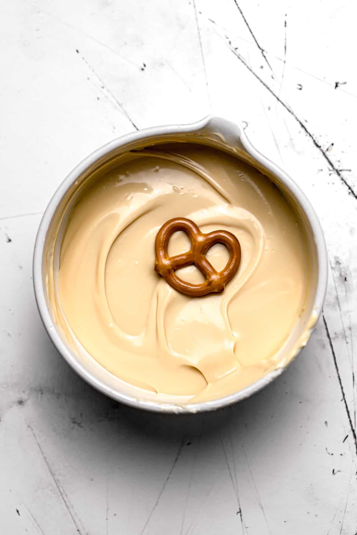 mini pretzel in bowl of melted caramelized white chocolate.