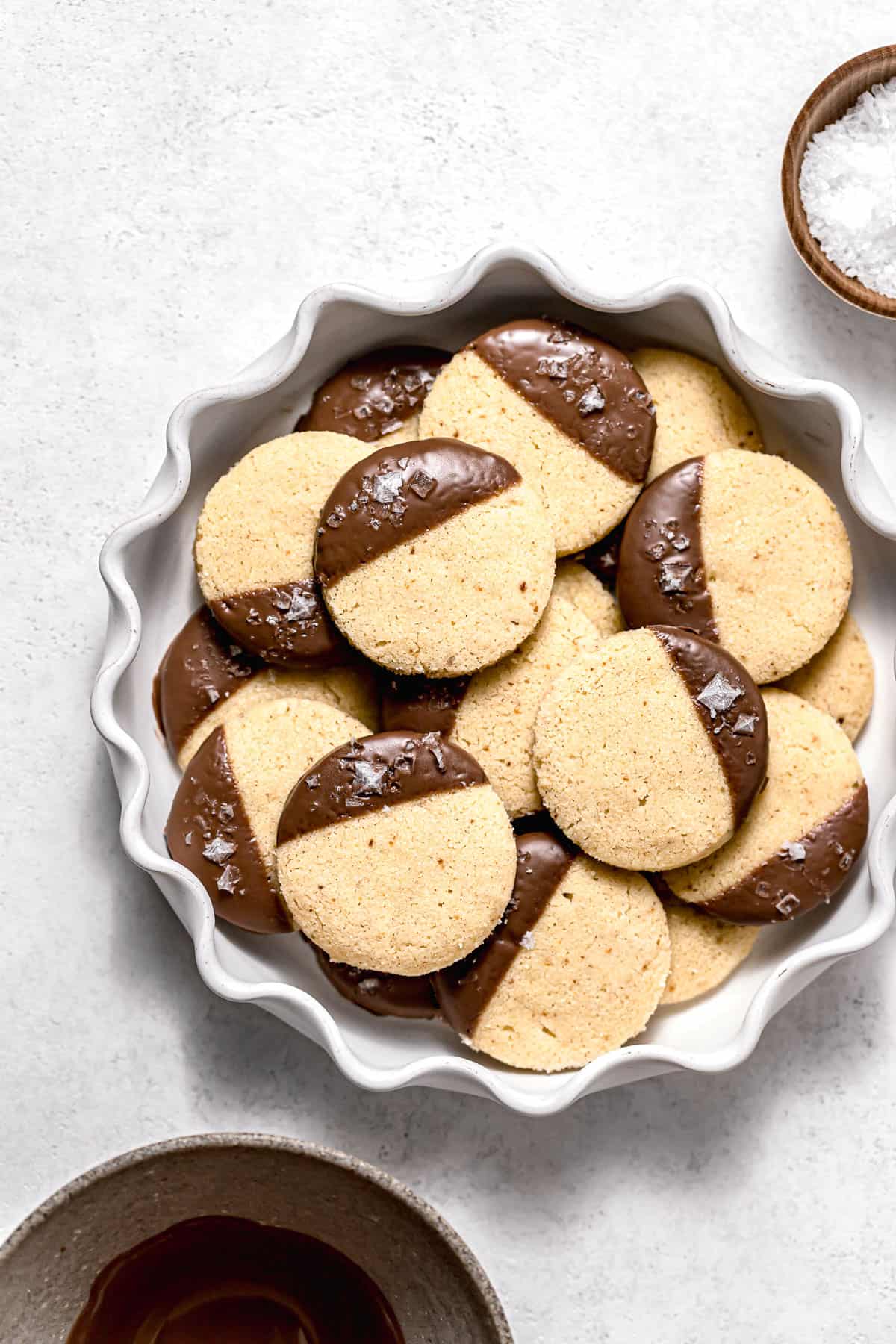 chocolate dipped shortbread cookies piled in white bowl.