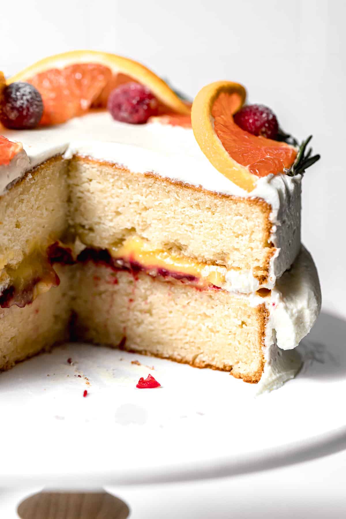 cranberry orange cake on cake stand cut to reveal inside texture.