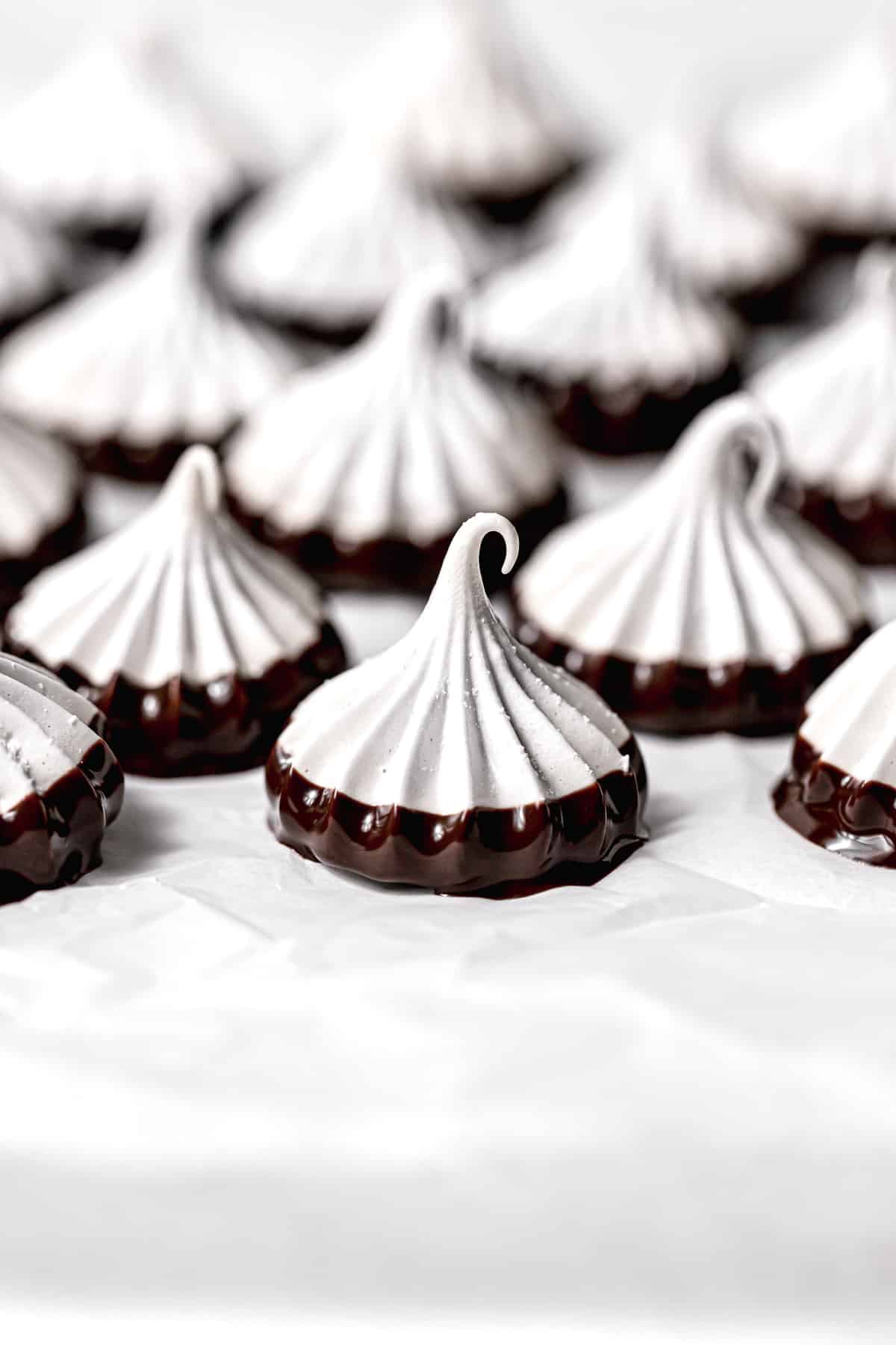 chocolate dipped meringue cookies on parchment paper.