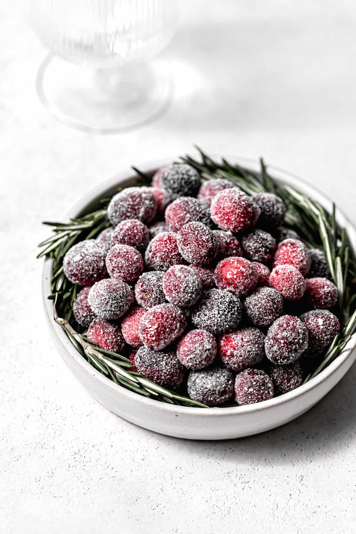 sugared cranberries and rosemary in bowl.