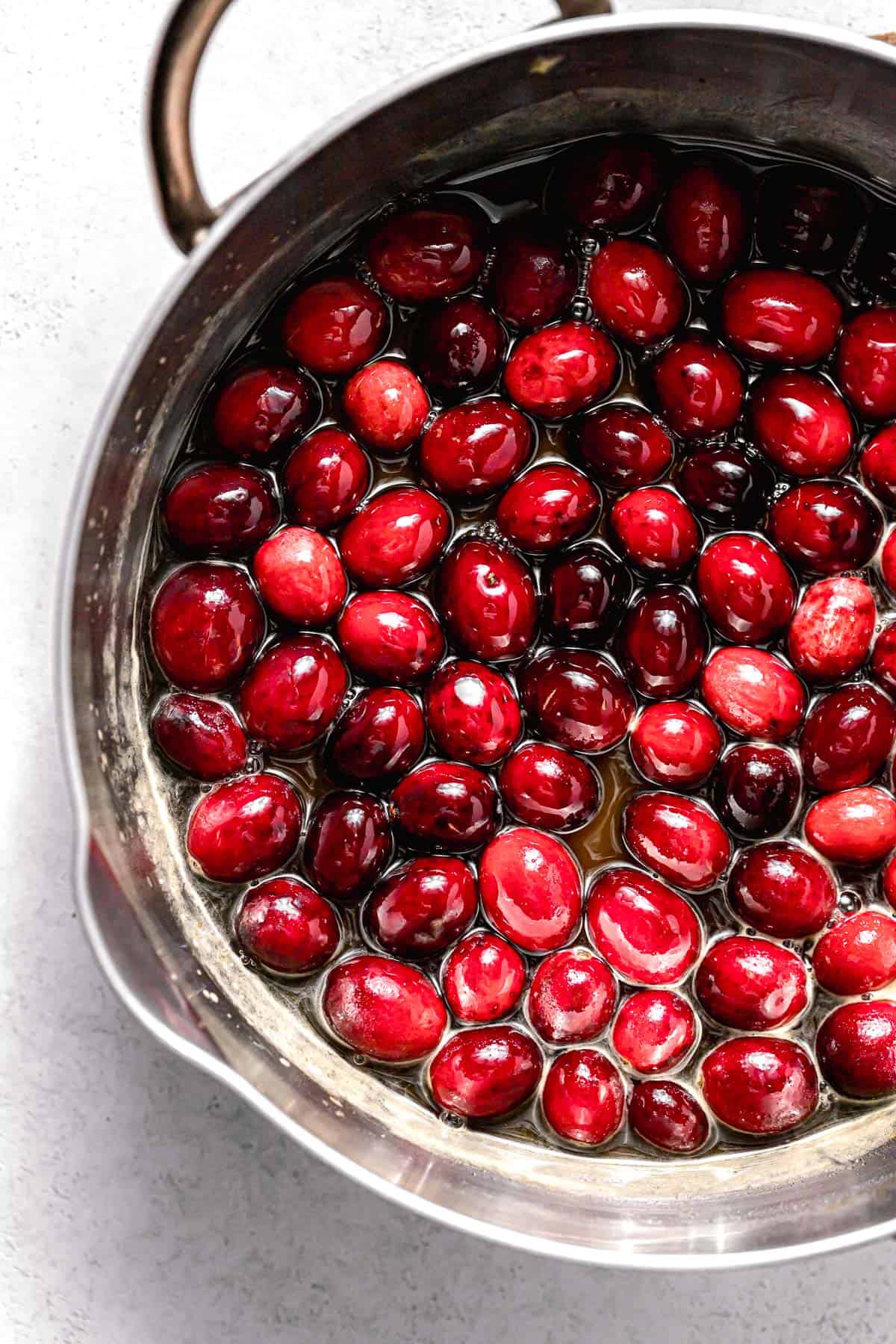 cranberries added to syrup in saucepan.