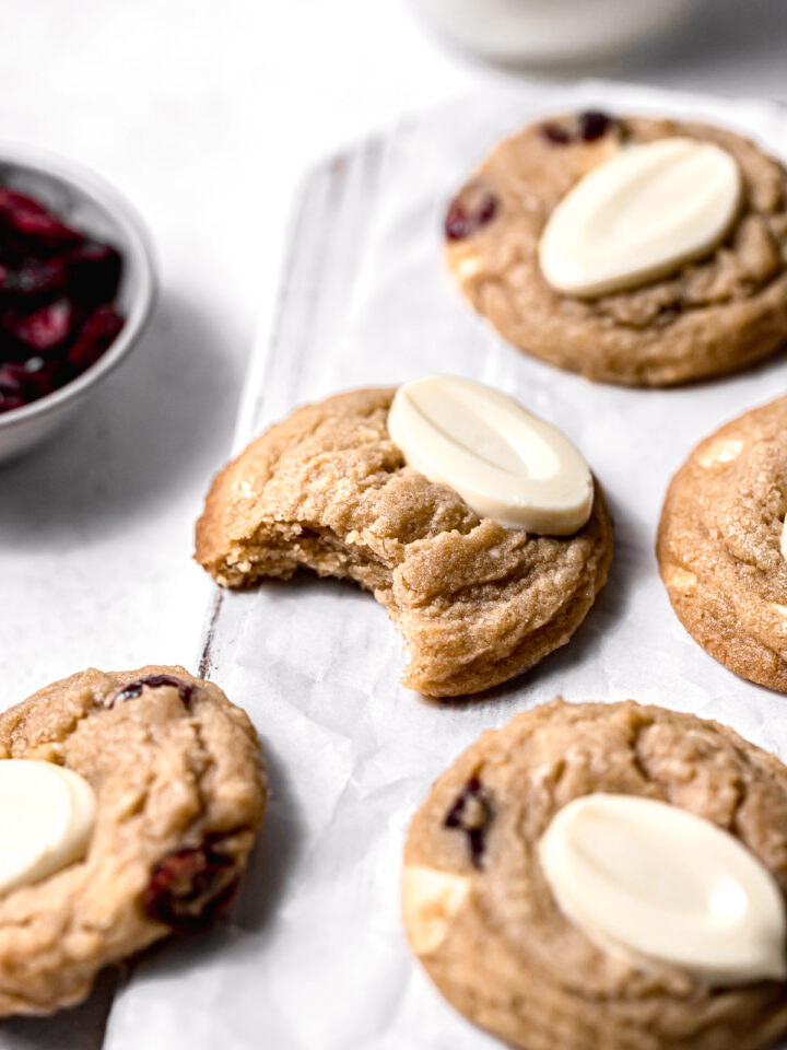 white chocolate cranberry cookies on white wooden board