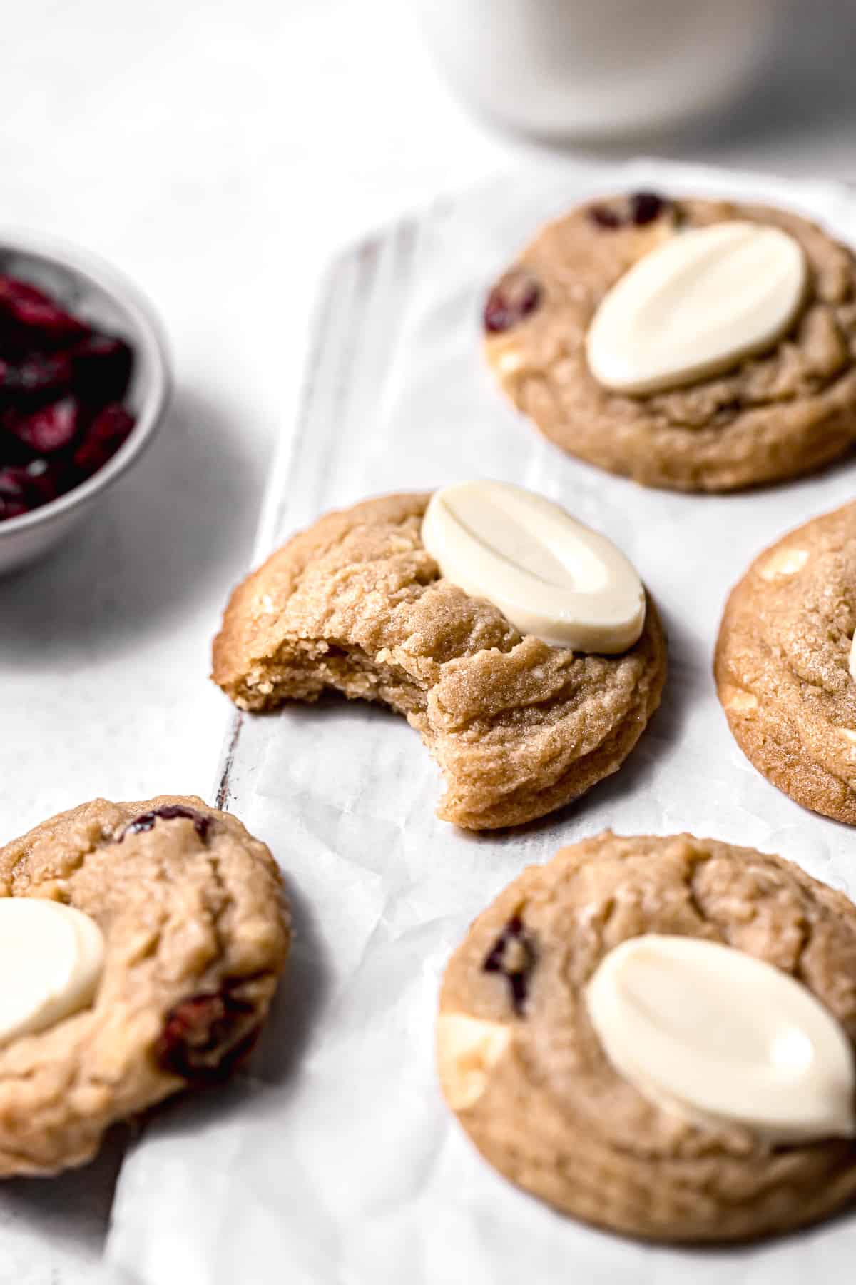 white chocolate cranberry cookies on white wooden board.