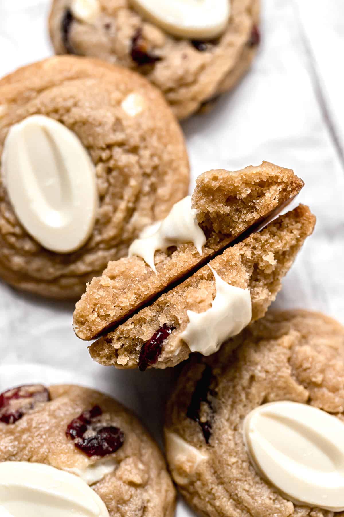 white chocolate cranberry cookie broken in half to reveal inside texture.